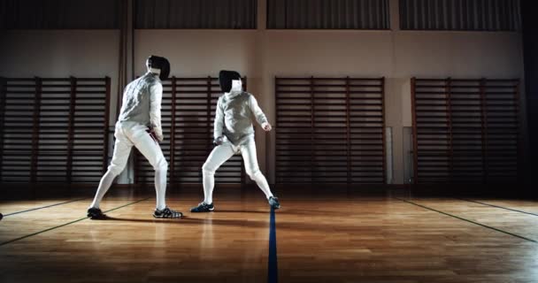 Zwei Männer in Fechtausrüstung duellieren sich mit Folien — Stockvideo