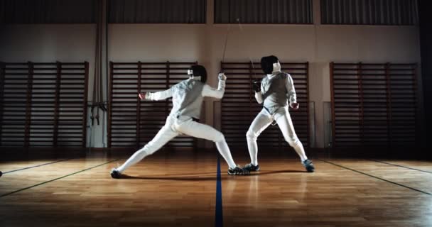 Two Men In Fencing Gear Duelling With Foils — Stockvideo