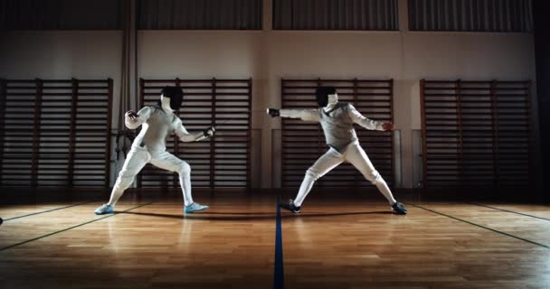 Zwei Männer in Fechtausrüstung duellieren sich mit Folien — Stockvideo