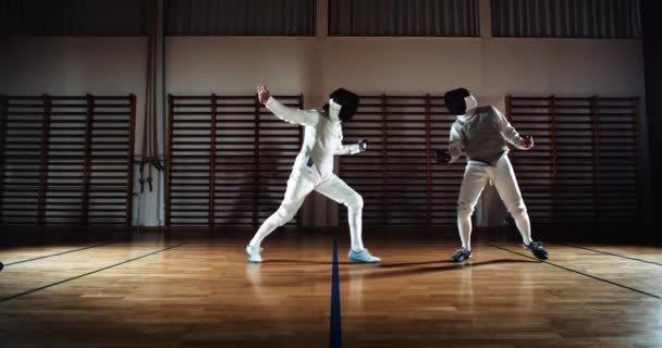 Two Men In Fencing Gear Duelling With Foils And Hi-Fiving After Battle — Stockvideo