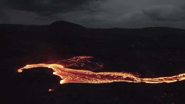 噴火する火山からの溶融溶岩の流れる川の上のドローン — ストック動画