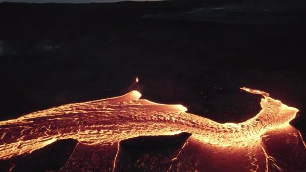 Drone richting stromende rivier van gesmolten Lava in zwart landschap — Stockvideo