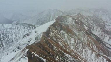 Bir tarafı karla kaplı Dağ Tepeleri üzerinde İHA uçuşu
