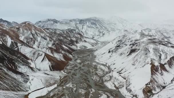 Drohne über schneebedeckter Gebirgslandschaft mit Fluss — Stockvideo
