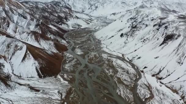 Drone sobre montañas cubiertas de nieve paisaje con lecho de río trenzado — Vídeos de Stock