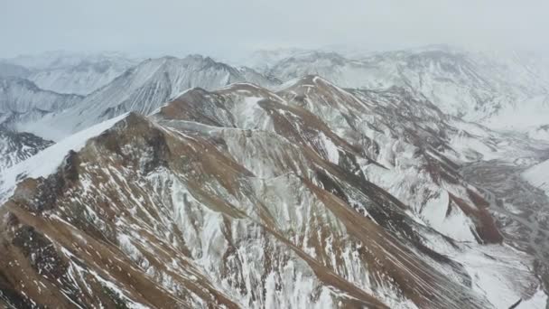 Drone sur les sommets enneigés des montagnes avec lit de rivière tressé ci-dessous — Video