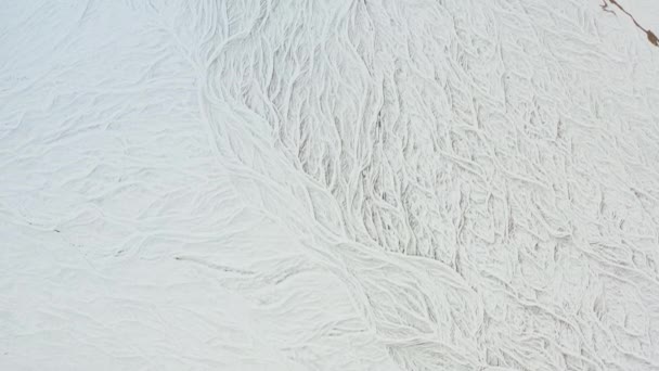 Drone sul paesaggio coperto di neve con il letto di fiume intrecciato congelato — Video Stock
