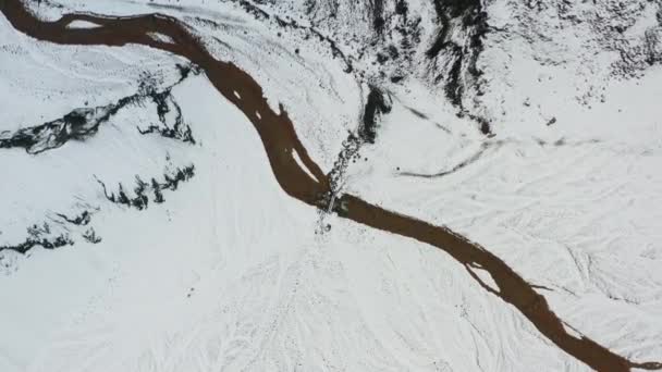 Дрон над снігом закритий пейзаж із замерзлим плетеним руслом — стокове відео