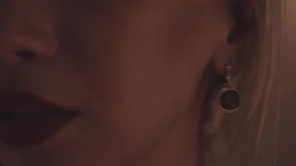 Frau schiebt sich mit opulentem Ohrring Haare hinter das Ohr — Stockvideo