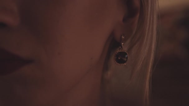 Жінка штовхає волосся за вухом з огидною сережкою — стокове відео