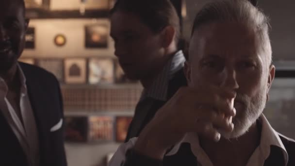 Muž sedí sám v baru kouření doutníku a pití panáka — Stock video