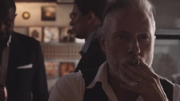 Mann sitzt allein an Bar und raucht Zigarre — Stockvideo