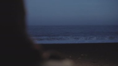 Karanlık çöktüğünde mağaradan Kara Kum Sahilinde Dalgaları İzleyen Adam