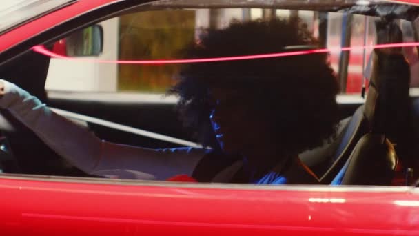 Femme avec Afro sortir du siège du conducteur de voiture rouge — Video