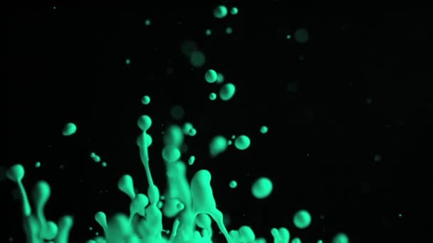 Groene druppels verf vliegen omhoog in de lucht — Stockvideo