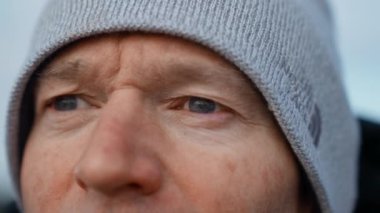 Vestrahorn Dağı 'na bakan yünlü şapkalı adamın, bir gözünden diğerine hareket eden mavi gözlerine yansıyan görüntüsü, İzlanda