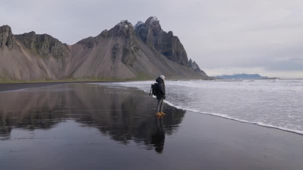 Людина з рюкзаком На мокрий берег біля гори Вестрагорн — стокове відео