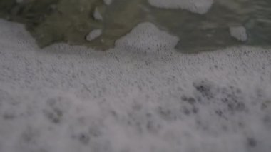 El kamerasıyla İzlanda 'da, Black Sand Beach' te hareket eden Baloncukların Yavaş Çekimi