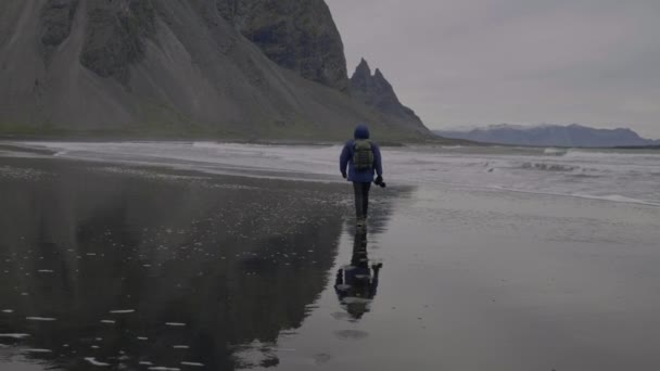 Wide Slow Motion Lockdown Shot Photographer Wandelen Zwart Zand Strand — Stockvideo