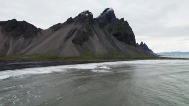 Denize, Kara Kum Plajına ve İzlanda 'daki Vestrahorn Dağı' na doğru ağır çekim uçağı