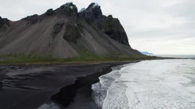 Wide Slow Motion İHA uçağı Denizin Ötesine Kara Kum Sahili ve Vestrahorn Dağı, İzlanda