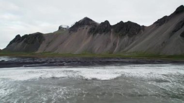 Geniş Yavaş Hareketli İHA Uçuşu Deniz, Kara Kum Kumsalı ve Vestrahorn Dağı, İzlanda