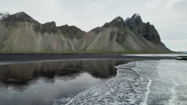 Wide Slow Motion İHA uçuşu Islak Kum Kumsalı ve Vestrahorn Dağı, İzlanda