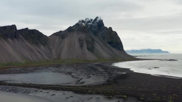 黒砂のビーチとアイスランドのヴェストラホーン山の上に広いスローモーションドローン飛行パンニング — ストック動画