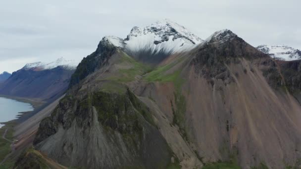 冰岛Vestrahorn山带着小河和雪的无人机从山尖起飞 — 图库视频影像