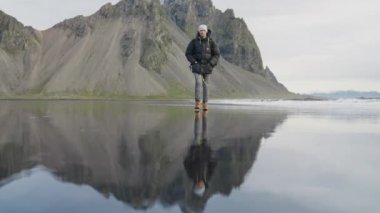 Vestrahorn Dağı 'ndan İzlanda' ya doğru Siyah Kum Sahili 'nde Yürüyen Yürüyüşçünün Sabit Yavaş Çekimi