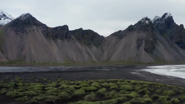 黒砂のビーチでモスから上昇するドローンは アイスランドのヴェストラホーン山を見るために — ストック動画