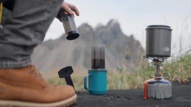 Adam Siyah Kum Üzerinde Kahve Hazırlıyor