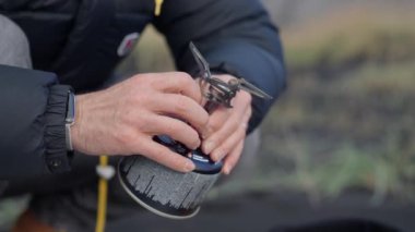 Adam sahilde kamp sobası yapıyor.