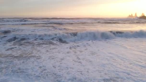 Беспилотник над залитым солнцем морем с морскими стеками на закате — стоковое видео
