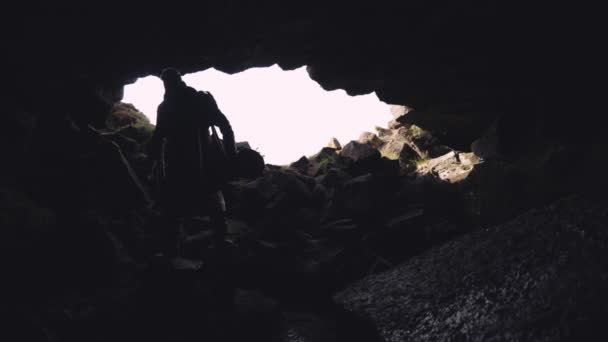 Man in lange jas met gitaar geval lopen in de grot — Stockvideo