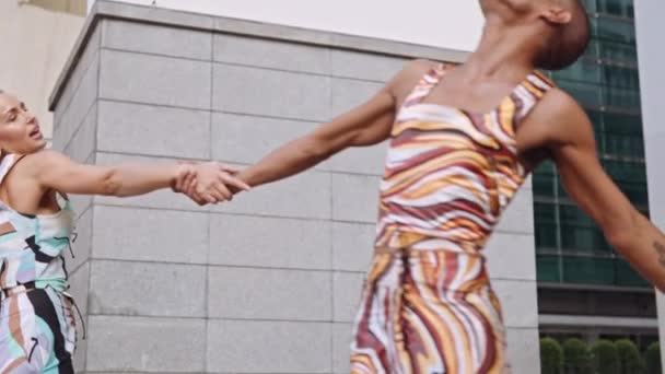 Modelos de moda bailando juntos en ropa de colores brillantes — Vídeo de stock