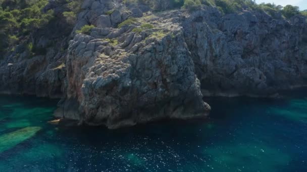Drone Arcing alrededor de la costa del acantilado rocoso y el mar azul de Ibiza — Vídeos de Stock