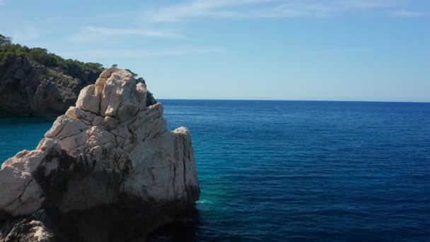 Drone alrededor de la gran formación rocosa en el mar que rodea Ibiza — Vídeo de stock