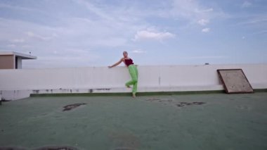 Kulüp elbiseli kadın şehir çatısı etrafında dönüyor.