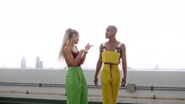Moda kıyafetli dansçılar çatıda gülüyor ve gülüyorlar.