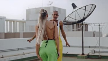 Moda mankenleri şehrin çatısında dans ediyorlar.