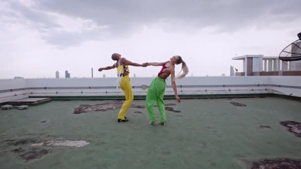 Modeller i klubbkläder dansar och uppträder tillsammans på skyskrapa — Stockvideo