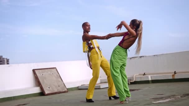 Танцюристи в клубному одязі тримаючи руки на спині і виконувати на міському даху — стокове відео