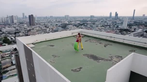 Drone Shot de modelos de moda mirando para bailar en la azotea de la ciudad — Vídeo de stock