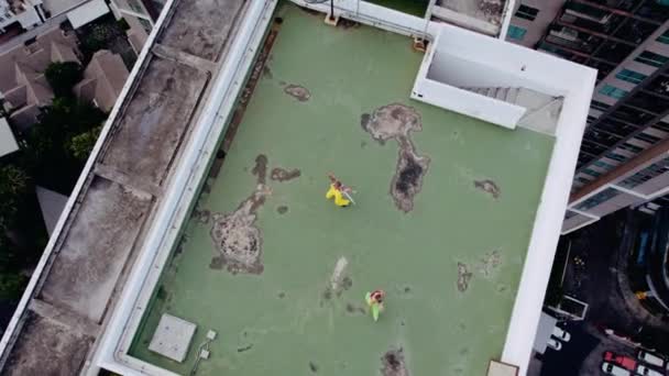 Drone Shot de modelos en verde y amarillo bailando en la azotea de la ciudad — Vídeo de stock
