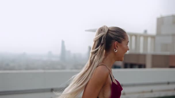 Zwei Models tanzen und lachen in Clubwear auf dem Dach der Stadt — Stockvideo
