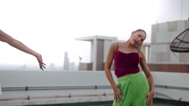 Motemodeller danser i klubbeklær på bytaket – stockvideo