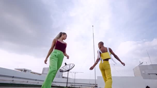 Танцівниці в клубному вбранні танцюють разом на хмарочосі — стокове відео