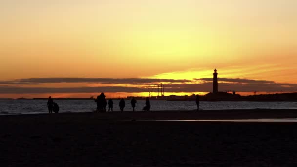Mensen wandelen langs Grenen Sandbar bij zonsondergang — Stockvideo