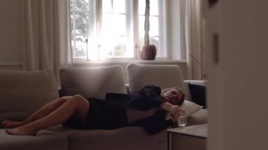 Takım Elbiseli İş Kadını Koltukta Rahatlıyor ve Akıllı Telefonla Konuşuyor